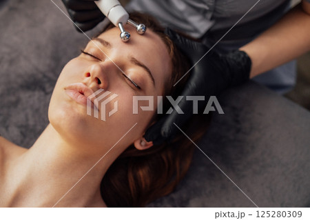 Microcurrent medicine treatment. Portrait of beautiful woman. Microcurrent medicine treatment. Portrait of beautiful woman. 125280309