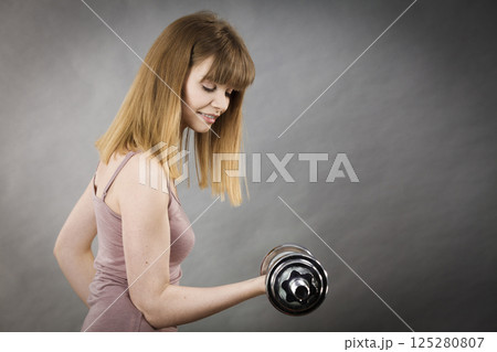 Woman working out at home with dumbbell 125280807