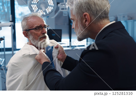 Aggressive man have conflict with doctor, holding him by coat. 125281310