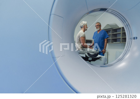 Doctor explaining CT scan results to patient in hospital setting Doctor explaining CT scan results to patient in hospital setting 125281320
