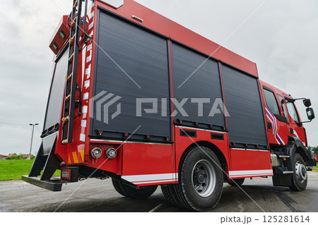 In this captivating scene, a state-of-the-art firetruck, equipped with advanced rescue technology, stands ready with its skilled firefighting team, prepared to intervene and respond rapidly to In this captivating scene, a state-of-the-art firetruck, equipped with advanced rescue technology, stands ready with its skilled firefighting team, prepared to intervene and respond rapidly to 125281614