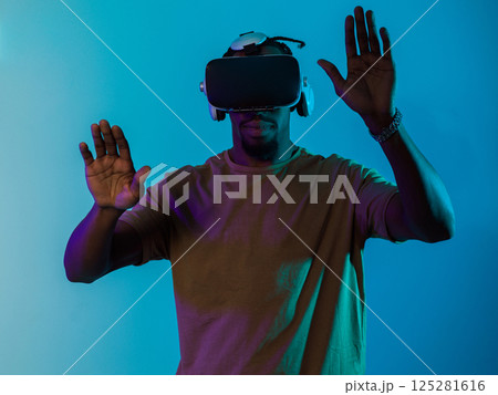 Immersed in a digital realm, an African American man navigates the virtual landscape with a VR goggles, using tactile gestures to interact with virtual objects, showcasing a harmonious blend of Immersed in a digital realm, an African American man navigates the virtual landscape with a VR goggles, using tactile gestures to interact with virtual objects, showcasing a harmonious blend of 125281616