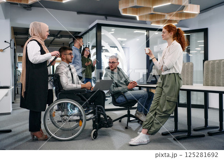 Young group of business people brainstorming together in a startup space, discussing business projects, investments, and solving challenges 125281692