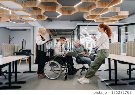 Young group of business people brainstorming together in a startup space, discussing business projects, investments, and solving challenges 125281768