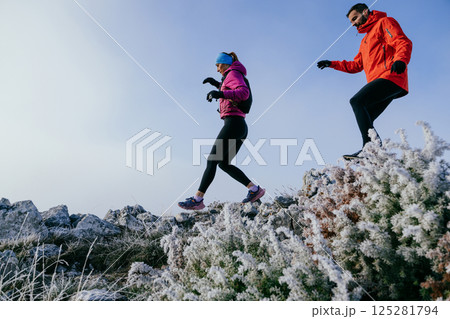 Trail running couple man and woman running on a mountain path Trail running couple man and woman running on a mountain path 125281794