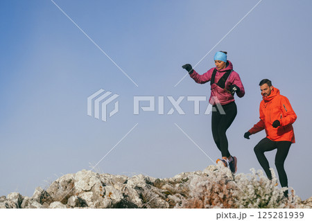 Trail running couple man and woman running on a mountain path Trail running couple man and woman running on a mountain path 125281939