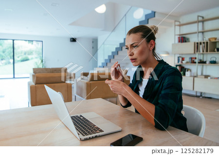 Woman sitting in living room using laptop looking at cam talk by video call with business friend relatives, head shot. Job interview answering questions 125282179