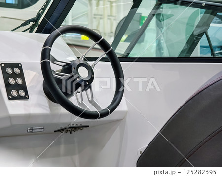Modern boat steering console showcasing advanced controls and sleek design in a marine setting 125282395