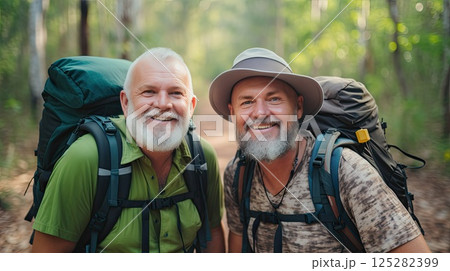Amidst towering mountains, two elderly men find solace in the simplicity of hiking. Their backpacks carry not only supplies but also the weight of cherished memories, laughter, and a friendship that 125282399
