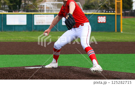 High School Baseball Pitcher Preparing to Throw on the Mound 125282715