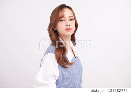 A beautiful young Asian woman with clean, fresh skin against a white background. Skincare, facial treatment, cosmetology, beauty, and spa. An elegant portrait of an Asian woman. 125282772
