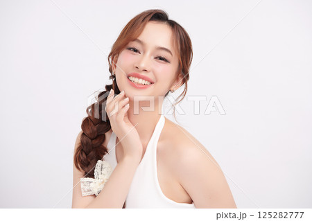 A beautiful young Asian woman with clean, fresh skin against a white background. Skincare, facial treatment, cosmetology, beauty, and spa. An elegant portrait of an Asian woman. 125282777