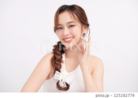 A beautiful young Asian woman with clean, fresh skin against a white background. Skincare, facial treatment, cosmetology, beauty, and spa. An elegant portrait of an Asian woman. 125282779