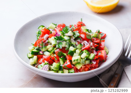 Vegetable salad with tomatoes, cucumbers, onions and parsley. 125282999