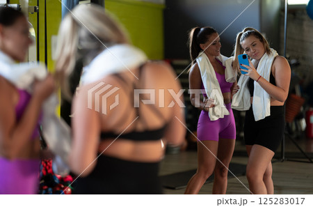Two fitness women posing for a photoshoot after an intense workout, capturing their strength, determination, and fitness journey. Two fitness women posing for a photoshoot after an intense workout, capturing their strength, determination, and fitness journey. 125283017
