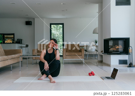 Woman Relaxing After Home Workout in a Modern Living Room Woman Relaxing After Home Workout in a Modern Living Room 125283061