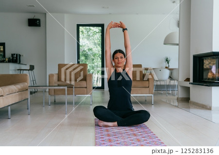 Young Beautiful Female Exercising, Stretching and Practising Yoga with Trainer via Video Call Conference in Bright Sunny House. Healthy Lifestyle, Wellbeing and Mindfulness Concept Young Beautiful Female Exercising, Stretching and Practising Yoga with Trainer via Video Call Conference in Bright Sunny House. Healthy Lifestyle, Wellbeing and Mindfulness Concept 125283136