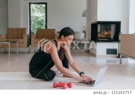 Young Beautiful Female Exercising, Stretching and Practising Yoga with Trainer via Video Call Conference in Bright Sunny House. Healthy Lifestyle, Wellbeing and Mindfulness Concept. 125283757