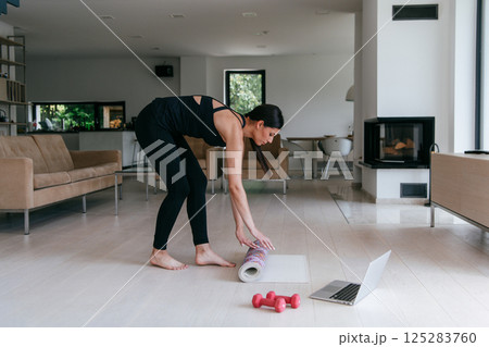 Young Beautiful Female Exercising, Stretching and Practising Yoga with Trainer via Video Call Conference in Bright Sunny House. Healthy Lifestyle, Wellbeing and Mindfulness Concept. 125283760