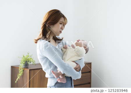 赤ちゃんを抱っこする可愛いママ 125283946