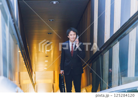 エスカレーターに乗るビジネスマン エスカレーターに乗るビジネスマン 125284120