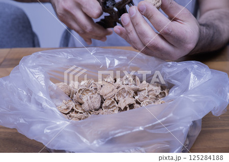 The man is cracking walnuts at home The man is cracking walnuts at home 125284188
