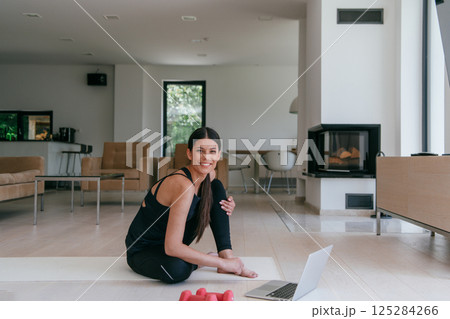 Young Beautiful Female Exercising, Stretching and Practising Yoga with Trainer via Video Call Conference in Bright Sunny House. Healthy Lifestyle, Wellbeing and Mindfulness Concept. 125284266