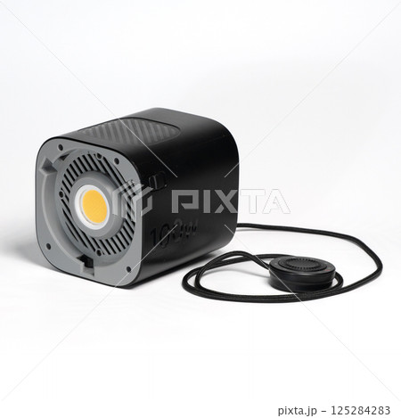 Black Aputure 100d LED light with foot stand and remote controller on white surface 125284283