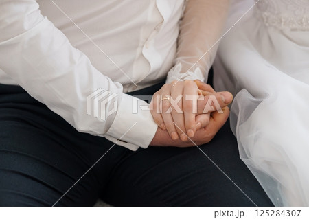 Close-up of Newly Married Couple Holding Hands with Wedding Rings, Symbolizing Love and Commitment During Post-Ceremony Moments, Displaying Joy, Togetherness, and Hope 125284307