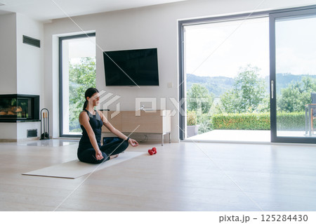 Young Beautiful Female Exercising, Stretching and Practising Yoga with Trainer via Video Call Conference in Bright Sunny House. Healthy Lifestyle, Wellbeing and Mindfulness Concept. Young Beautiful Female Exercising, Stretching and Practising Yoga with Trainer via Video Call Conference in Bright Sunny House. Healthy Lifestyle, Wellbeing and Mindfulness Concept. 125284430