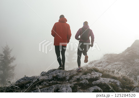 Trail running couple man and woman running on a mountain path 125284520