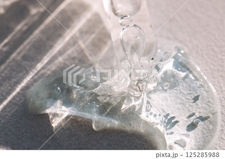 Close-up of a glass pipette with transparent gel with bubbles. Cosmetic products Close-up of a glass pipette with transparent gel with bubbles. Cosmetic products 125285988