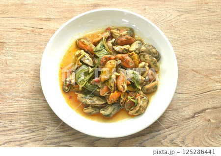 spicy stir fried mussel with chilin and basil leaf in curry sauce on plate  125286441