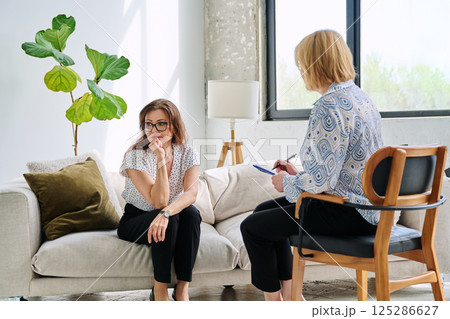 Unhappy sad middle aged woman in therapy session in psychologist therapist office 125286627
