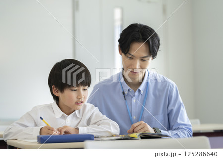 勉強する小学4年生の男の子と先生 勉強する小学4年生の男の子と先生 125286640