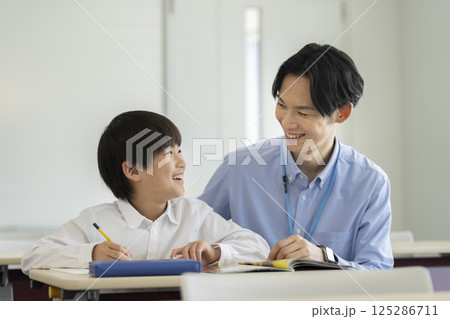 勉強する小学4年生の男の子と先生 125286711