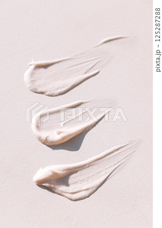 Close-up of the texture of pink cream on a light background. Moisturizing serum is smeared on the backdrop Close-up of the texture of pink cream on a light background. Moisturizing serum is smeared on the backdrop 125287288