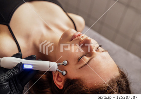 Microcurrent medicine treatment. Portrait of beautiful woman. 125287387