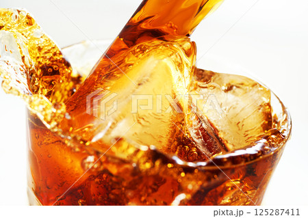 グラスに勢いよく注がれるアイスコーヒーとスプラッシュ 125287411