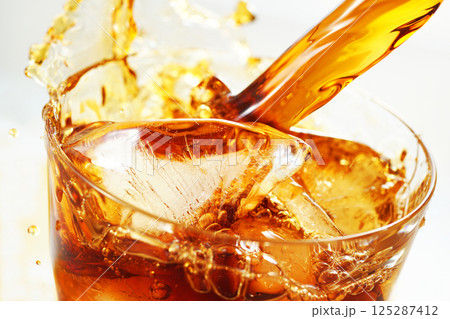 グラスに勢いよく注がれるアイスコーヒーとスプラッシュ 125287412