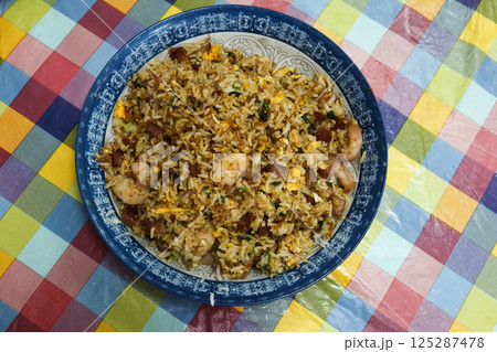 Close up of homemade Chinese Canton style shrimp char siu pork egg fried rice on a plate with colourful table cloth Close up of homemade Chinese Canton style shrimp char siu pork egg fried rice on a plate with colourful table cloth 125287478