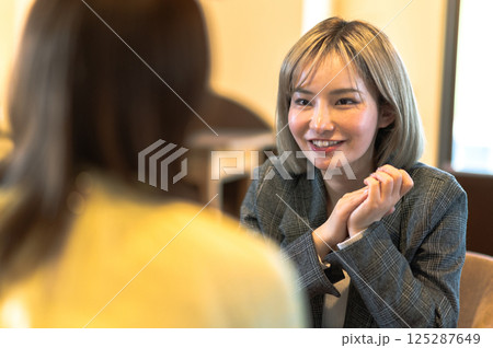 喫茶店で会話する若い2人の女性 125287649