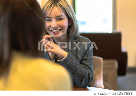 喫茶店で会話する若い2人の女性 125287651