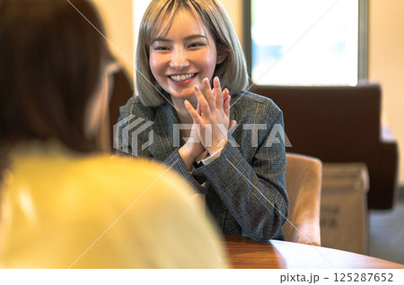 喫茶店で会話する若い2人の女性 125287652