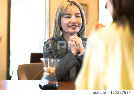喫茶店で会話する若い2人の女性 喫茶店で会話する若い2人の女性 125287654
