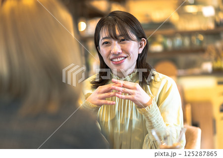 喫茶店で会話する若い2人の女性 125287865