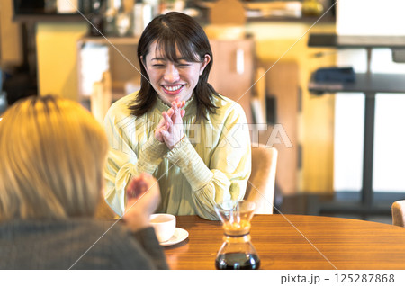 喫茶店で会話する若い2人の女性 喫茶店で会話する若い2人の女性 125287868