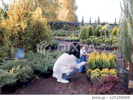 A young Korean woman and her cute daughter are walking in the garden A young Korean woman and her cute daughter are walking in the garden 125289099