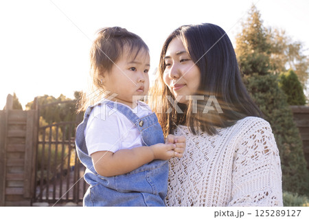 An attractive mom walks with her cute girl outdoors 125289127