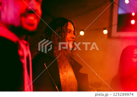 Friends celebrate at a lively indoor gathering with drinks and warm lights during a joyful evening Friends celebrate at a lively indoor gathering with drinks and warm lights during a joyful evening 125289974